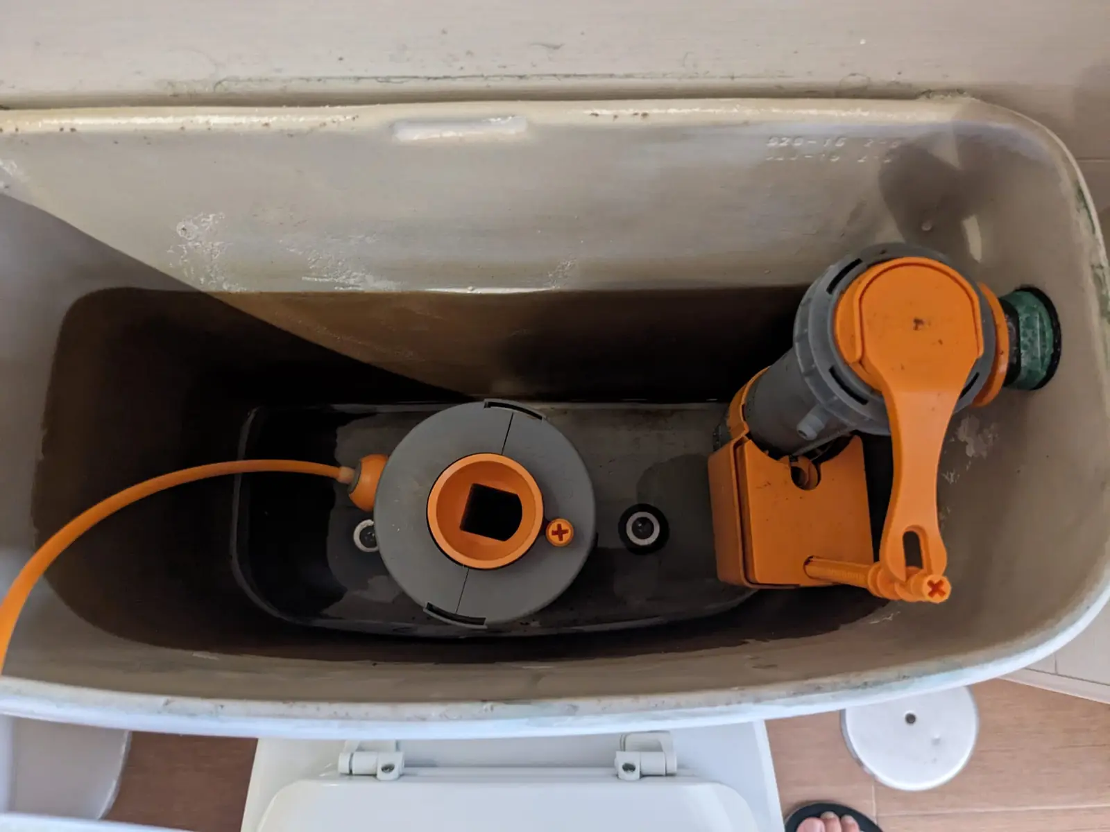 Cisterna abierta con mecanismo de descarga y válvula de llenado de color naranja