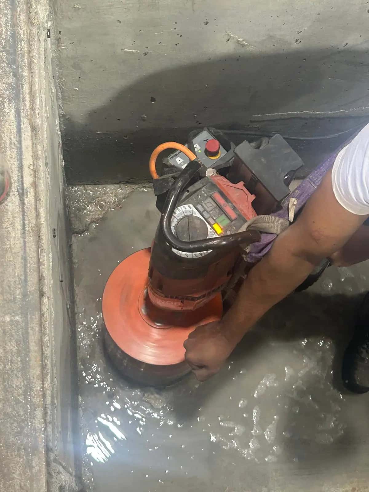 Perforadora con corona de diamante taladrando un suelo de hormigón con agua