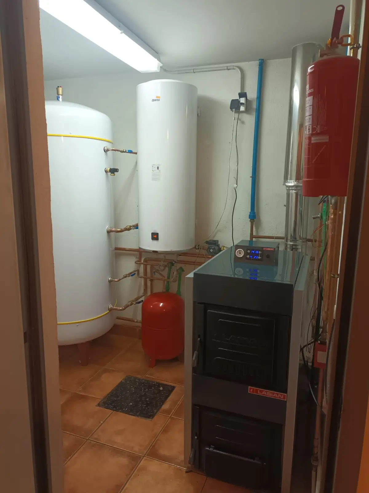Sala de calderas con acumulador, termo, vaso de expansión y caldera de combustible sólido